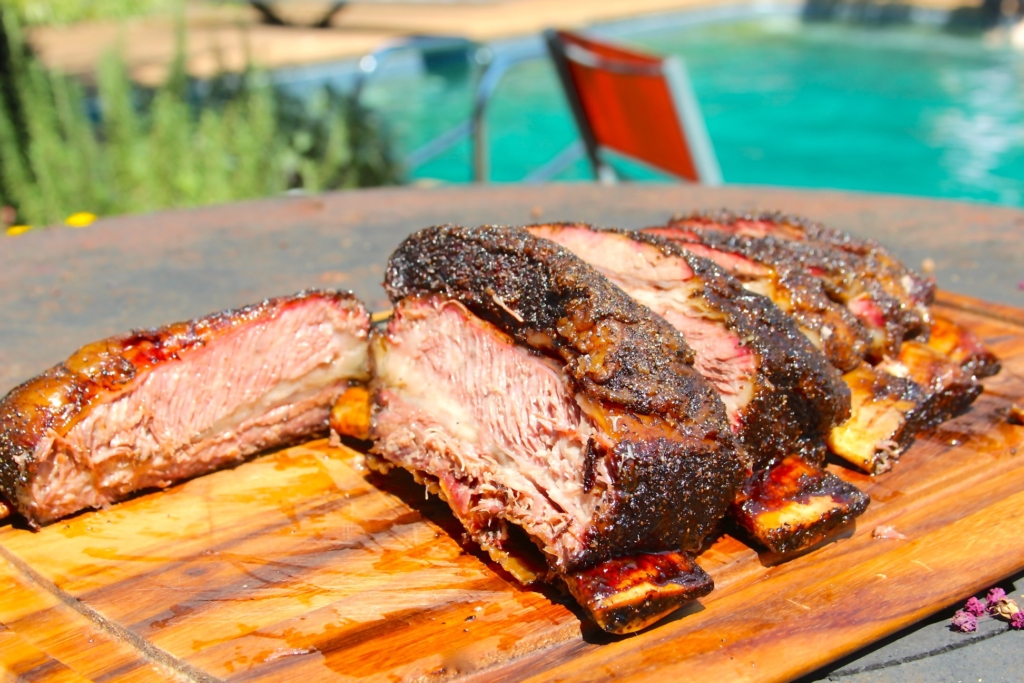 Sliced BBQ beef ribs on a cutting board.
