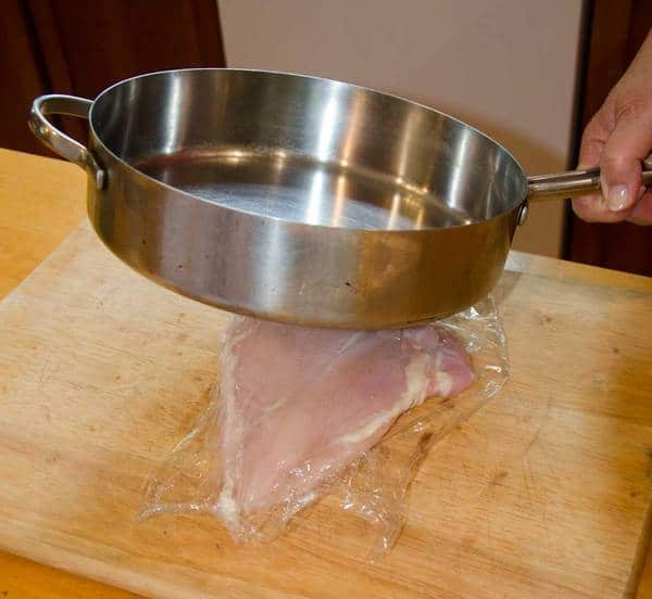pounding chicken with a sauce pan pounding chicken with a sauce pan