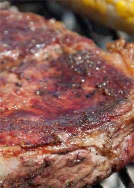 ribeye on grill with juice pooling ribeye on grill with juice pooling