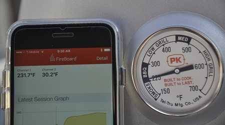 A smartphone on the left with a thermoeter app showing temperature. On the right is a round thermometer showing the same temperature.